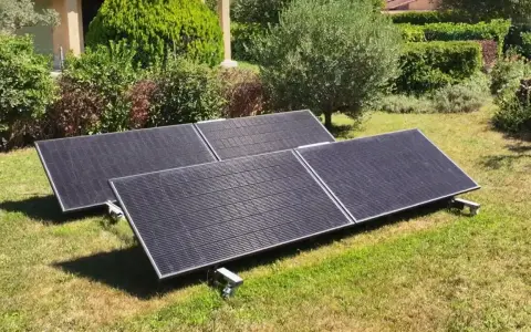 Panneaux solaires sur pelouse, promesse de rentabilité panneau solaire autoconsommation. Jardin verdoyant, maison en arrière-plan.