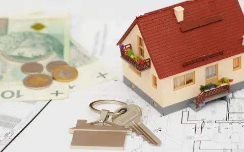 Model domu, klucze, pieniądze i plany architektoniczne.