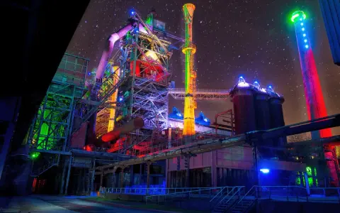 Industrielles Lichterspiel im Landschaftspark Duisburg unter sternklarem Himmel. Bunte Beleuchtung verwandelt die Stahlriesen in ein Kunstwerk.