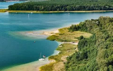 Turkusowa woda, piaszczyste plaże i zielone lasy tworzą malowniczy krajobraz. To **najczystsze jezioro w Polsce**, idealne do żeglowania i wypoczynku.