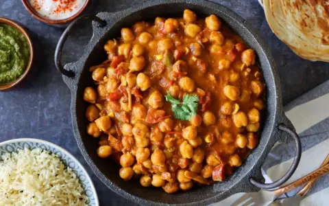 Potaje de garbanzos en salsa con cilantro, acompañado de arroz blanco y pan.