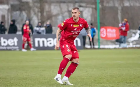 Piłkarz Alan Uryga w czerwonej koszulce z numerem 6, na boisku. Miejmy nadzieję, że jego kontuzja nie jest poważna.