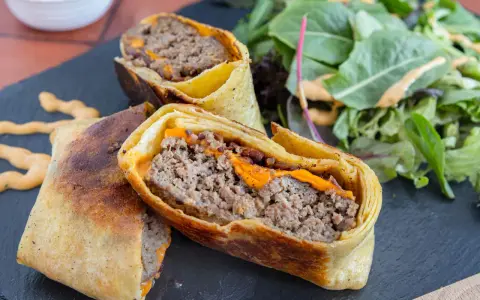 Herzhafte Burger Wraps mit geschmolzenem Käse und einem Beilagensalat.