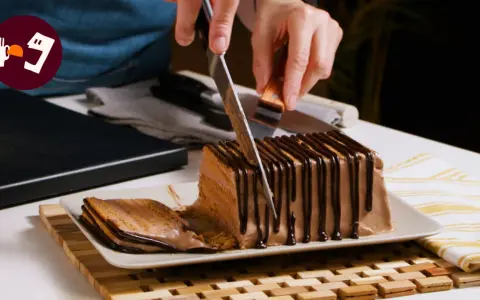 Cortando una porción de la deliciosa tarta de queso casera de la abuela, cubierta con chocolate.