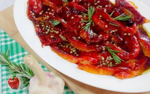 Geröstete Paprika in Öl mit Knoblauch und Rosmarin, ein köstliches Paprika Antipasti Rezept aus der Pfanne.