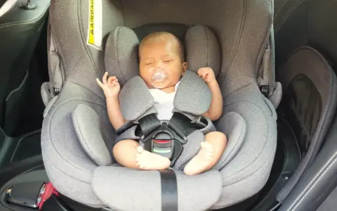 Bebé dormido en su silla de coche, un paso clave para como acostumbrar a un bebé al coche y viajar seguros.