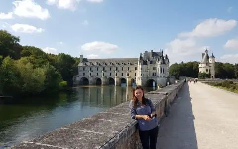 Kobieta na moście przed zamkiem Chenonceau, nad rzeką Cher, dopływem najdłuższej rzeki Francji, Loary.