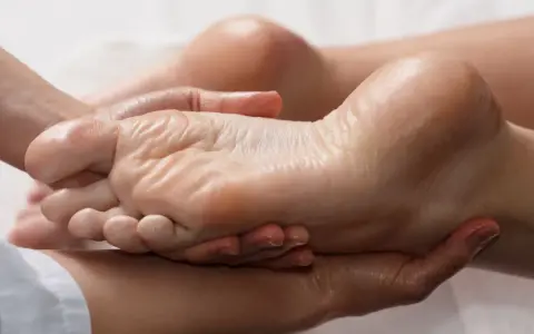 Mains expertes prodiguant un massage relaxant pour une manucure pied parfaite, hydratant et apaisant.