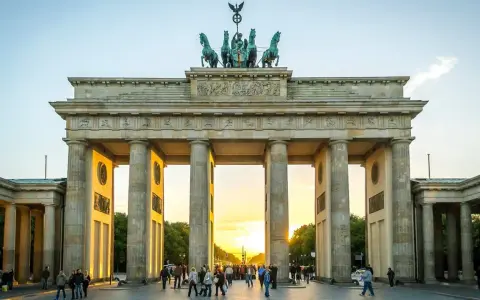 Brandenburger Tor i Berlin, en ikonisk sevärdhet som visar vad man ska se i Berlin. Solnedgången lyser upp monumentet och folklivet.