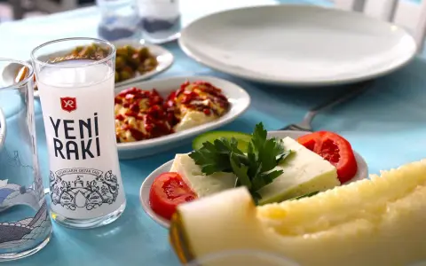 Ein Glas Yeni Raki, Käse, Tomaten und Melone – so trinkt man Raki in geselliger Runde.