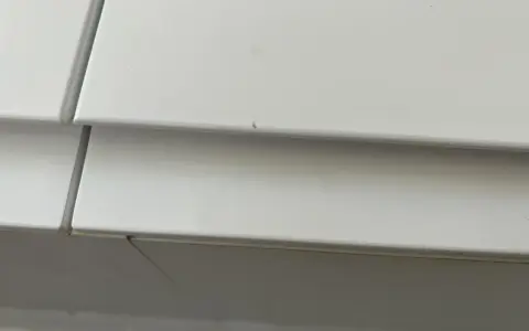 Detalle de un mueble lacado blanco con pequeños arañazos, listo para reparar.