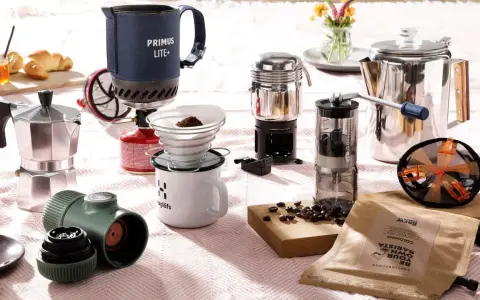 Perfekt für Kaffee kochen Camping: Mokkakanne, Filterkaffee-Set, French Press und Kaffeemühle auf einer Decke.