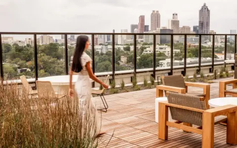 Frauen auf einer Dachterrasse mit Blick auf eine Stadt der kurzen Wege. Moderne Möbel laden zum Verweilen ein.