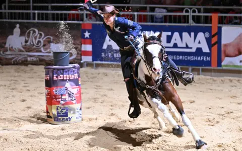 Reiterin im schnellen Galopp um eine Tonne beim Americana Friedrichshafen.