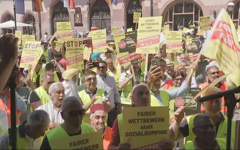 Demonstranten mit gelben Schildern fordern "Fairer Wettbewerb statt Sozialdumping" und "Mindestpreise für alle". Ein **Taxi-Streik** ist im Gange.