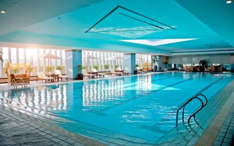 Relaks w hotelu z basenem na Podlasiu. Długi, błękitny basen z leżakami i parasolami, idealny na wakacje.