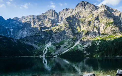 Morskie Oko, Tatry. Majestatyczne góry odbijają się w krystalicznie czystej wodzie, ukazując głębokość jeziora.