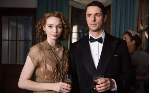 Ett elegant par med drinkar i handen, en scen från huset på udden serie. Kvinnan bär en brun klänning, mannen en smoking.
