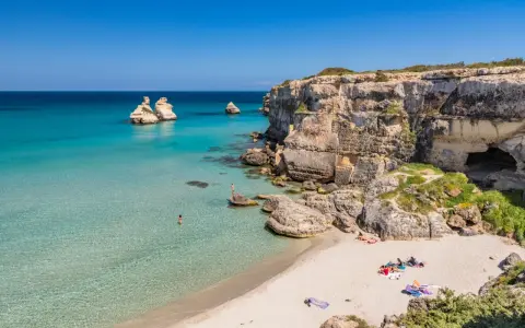 Spiaggia con scogli e mare cristallino, un angolo di paradiso in Puglia dove andare al mare.