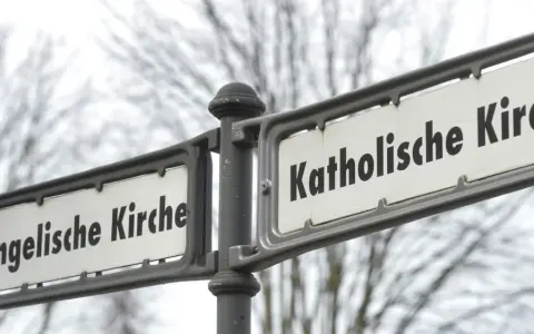 Straßenschilder weisen den Weg zur Evangelischen und Katholischen Kirche. Ein sichtbarer Unterschied katholisch evangelisch.