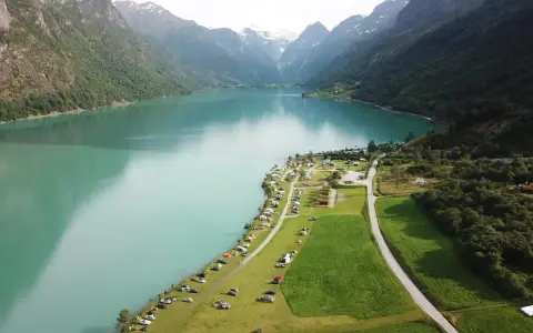 Vacker vy över en sjö med berg och campingplatser i Norge. Perfekt för dig som söker campingplatser Norge.