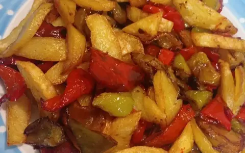 Patate fritte croccanti e peperoni colorati, un contorno saporito che ricorda la semplicità delle pipi e patate fatte in casa.