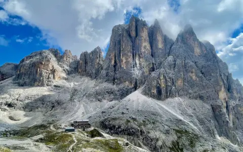 Rifugio alpino ai piedi di imponenti vette dolomitiche, ideale per un trekking di 5 giorni.