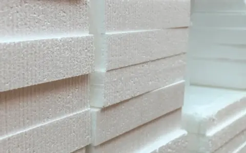 Stos płyt styropianowych, idealnych na mur 40 cm. Grubość i struktura materiału sugerują doskonałą izolację termiczną.
