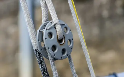 Système de poulies avec cordages en Dyneema, offrant une résistance exceptionnelle pour les manœuvres de voile.