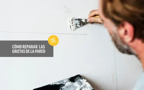 Hombre repara grietas en pared con aguaplast. Aprende por qué se agrieta el aguaplast y cómo solucionarlo.