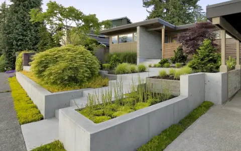 Modern entré inspiration utomhus med betongmurar, trappor och frodig grönska. En inbjudande och stilren design.