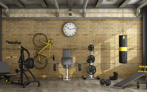 Ett välutrustat gym i garaget med vikter, boxningssäck, cykel och träningsbänk.