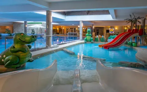 Wesołe dinozaury i zjeżdżalnie w aqua parku hotelowym zapraszają do zabawy w wodzie.