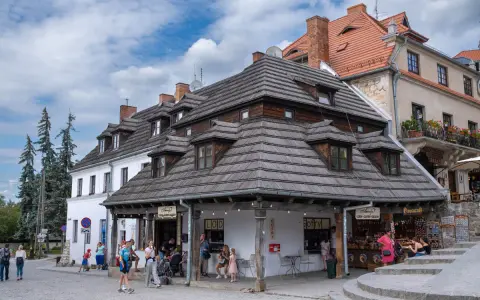 Kazimierz Dolny rynek tętni życiem. Ludzie spacerują, kupują lody i gofry pod urokliwymi, drewnianymi dachami kamienic.