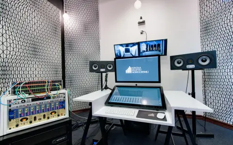 Profesjonalny komputer do muzyki w studiu nagraniowym, z monitorami studyjnymi i rackiem sprzętu audio.