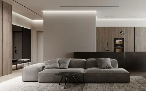 Soggiorno moderno con divano grigio, tavolino nero e cucina a vista. Un pilastro centrale, illuminato da luci a led, offre spunti su come abbellire un pilastro in soggiorno.