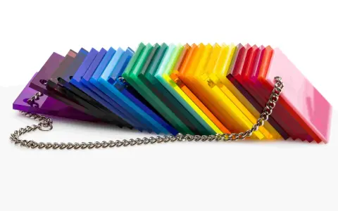 A rainbow fan of acrylic sheets, showcasing varying shades and the material's density, is held together by a silver chain.