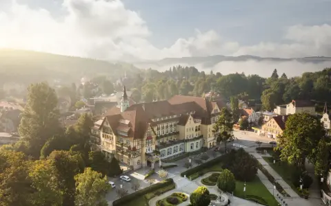 Sanatorium Polonia w Kudowie Zdroju, z pięknymi pokojami i otoczeniem, w mglisty poranek.