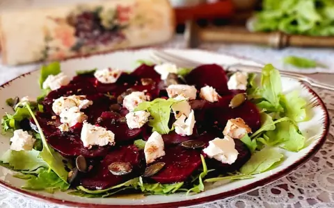 Pyszne carpaccio z buraka z serem feta i pestkami dyni na talerzu.