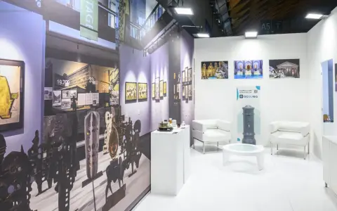 Stand espositivo con opere d'arte e arredi moderni, pronto per il meeting Rimini 2026.