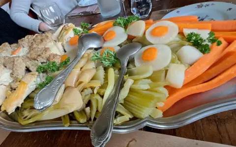 Plat généreux d'un restaurant du terroir : viandes, légumes racines et légumes verts, prêt à être dégusté.