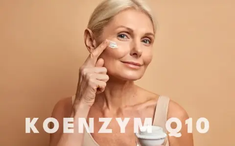 Kobieta aplikuje krem z koenzymem Q10 na skórę wokół oczu. Koenzym Q10 na co? Na odmłodzenie i regenerację.