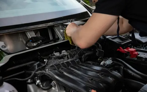 Mechanik sprawdza, dlaczego przekaźnik cyka, a rozrusznik nie kręci. Widok na silnik i przewody.