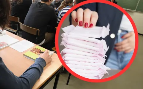 W sali lekcyjnej, gdzie uczniowie siedzą przy ławkach, widać stos podpasek. To ważny element higieny, który może pomóc w codziennym funkcjonowaniu.