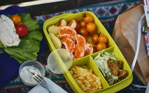 Piknikowy lunch: kurczak, pomidorki, mandarynki, jajecznica i surówka. Czy można wziąć jedzenie do samolotu Ryanair? Takie posiłki są idealne na podróż.