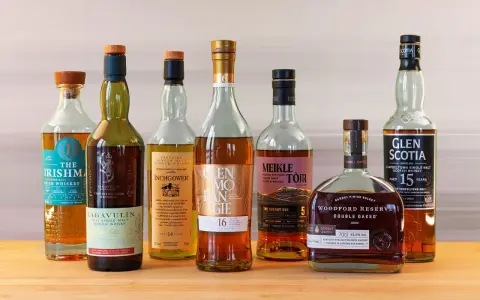 Eine Auswahl von sieben Flaschen, darunter Irish Whiskey und Scotch, die zu den top 10 besten Whisky zählen könnten.