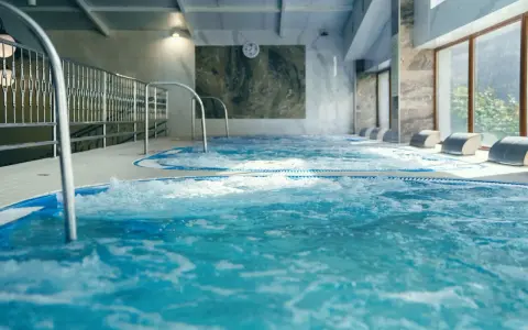 Relaks w hotelu z basenem w Białymstoku. Bąbelki unoszą się w wodzie jacuzzi, zapraszając do odpoczynku.