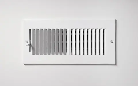 Grille de ventilation blanche, partie intégrante d'une installation pompe à chaleur air air gainable, pour une diffusion discrète de l'air.
