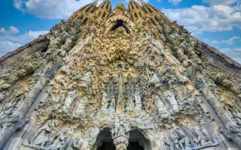 La Sagrada Familia, un capolavoro architettonico, si erge maestosa. La sua facciata è un tripudio di sculture, un racconto visivo che si estende dalla **distanza porto Barcellona Sagrada Familia**.