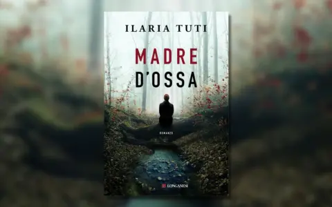 Copertina del romanzo "Madre d'ossa" di Ilaria Tuti. Una figura solitaria siede in un bosco nebbioso, vicino a un ruscello.